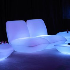 an illuminated couch and chair in a dark room