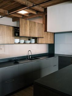 a kitchen with wooden cabinets and black counter tops in an industrial style home or office