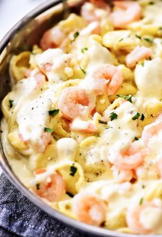 shrimp tortellini alfredo in a skillet with text overlay