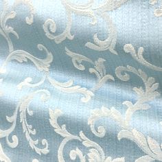 a blue and white fabric with an intricate design on it's side, as well as the background