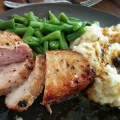 a plate with meat, mashed potatoes and green beans