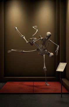 a skeleton is dancing on a red carpet in front of a brown wall with lights