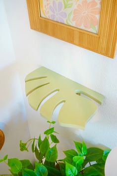 a potted plant sitting on top of a wooden table next to a framed picture