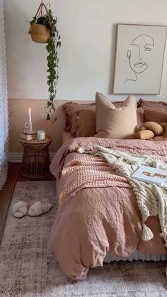 a bed with pink linens and pillows in a white room next to a window