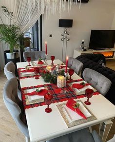 the table is set with red and white placemats, candles, and napkins