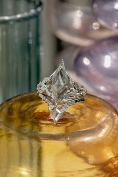 a diamond ring sitting on top of a yellow vase