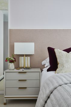 a bed with two nightstands next to each other and a lamp on top of it