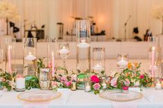 the table is set with silverware and white flowers