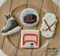 decorated cookies on a plate with ice skates, hockey puckers and birthday cake