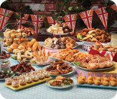 a table filled with lots of different types of food and desserts next to flags