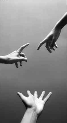 four hands reaching for each other in the air