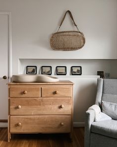 a baby crib in the corner of a room with pictures on the wall above it