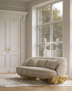 a couch sitting in front of a window on top of a hard wood floor next to a white door