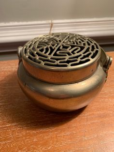 a metal container sitting on top of a wooden table