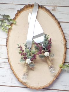 a pair of scissors sitting on top of a piece of wood with succulents