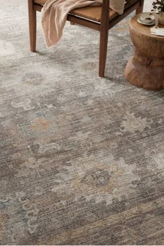 an area rug in the middle of a living room with a chair and coffee table