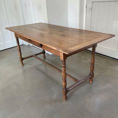 an old wooden table sitting in a room next to a white door and two doors