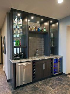 a home bar with stainless steel appliances and liquor bottles