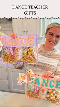 a woman holding up two bags filled with snacks and candy, while the words dance are written on them