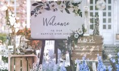 a welcome sign sitting in the window of a flower shop