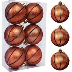 six basketballs are in a clear box with gold trim around the edges and on each ornament