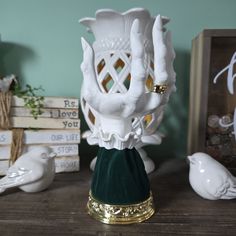 a white vase sitting on top of a wooden table next to other items and decor