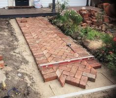 a brick walkway being built in front of a house