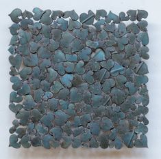 a piece of art that is made out of rocks and has blue paint on it