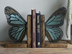 two bookends made out of wood and stained glass, each with a butterfly