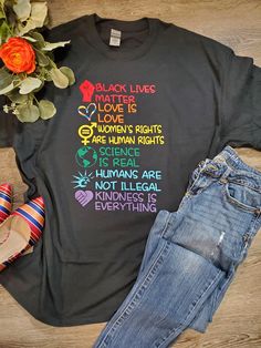 a t - shirt that says black lives matter on it next to some shoes and flowers