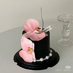 a black and white cake with pink flowers on it