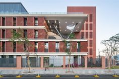 the building is made out of red bricks and has an open balcony above it that overlooks the street