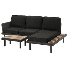 two black couches sitting next to each other on top of a wooden coffee table