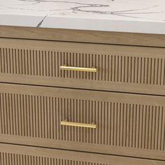 a close up of a wooden dresser with drawers and marble counter top in the background