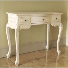 a white desk with two drawers on the top and one drawer at the bottom, in front of a beige wall