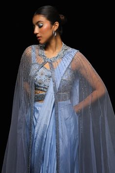 Blue enclosed neck long net cape with astral encrustments using metallic nalki, starry rays patterned cut dana, glass beads embellishments. Paired with a pleated pallu pre-draped crepe saree and strap sleeves starry stellar cut dana, beads embellishments sweetheart neck blouse with encrusted attached belt. - Aza Fashions Drape Sari, Sweetheart Neck Blouse, Crepe Saree, Drape Saree, Blue Saree, Blouse Sleeveless, Sweetheart Neck, Sarees Online, Set For Women