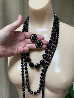 "Some ladies like only pearls. Others like bright colored pieces of jewelry. And you might be the lady who, like me, likes black jewelry. For that reason I have compiled 3 black and gold bead necklace with a pair of black and gold clip on earrings to wear together or in any arrangement you might like. Especially nice for the lady who wears lots of black and white clothing and is always looking for jewelry to go with. The longest necklace doesn't have any gold beads. Spring ring clasp. Knotted be Black And White Clothing, Black Gold Earrings, Graduated Pearl Necklace, Black Gold Necklace, Gold Jewelry Set, Necklaces Black, Black Gold Jewelry, White Clothing, Bead Necklaces