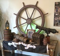 an old ship wheel and other items on a table in a room with white walls