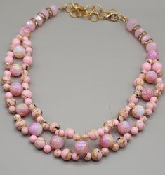 Bright pink and gold choker necklace made with large and small pink shell turquoise beads and pink glass beads. Two strands woven together to create Figaro pattern. Small with lobster claw clasp and jump rings to adjust for any size