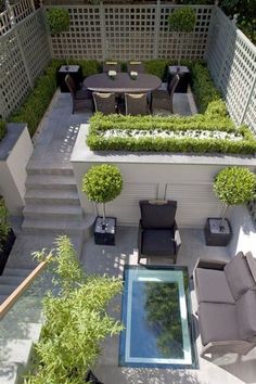 an aerial view of a patio with seating and plants in the center, surrounded by greenery