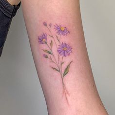 a woman's arm with purple flowers tattooed on the left side of her leg