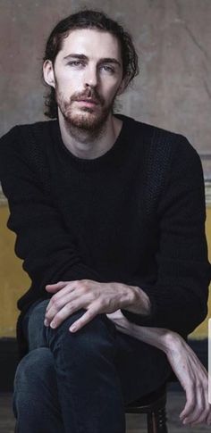 a man sitting in a chair with his arms crossed and looking off to the side