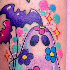 a colorful tattoo with an image of a ghost on it's leg and flowers in the background