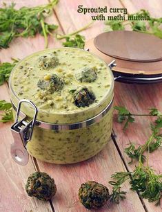 broccoli soup in a pot on a wooden table next to other food items