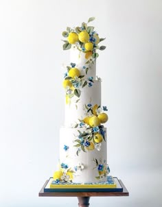 a three tiered cake with lemons and blue flowers