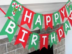 a happy birthday banner with candy canes hanging on a fireplace mantel in front of a brick wall