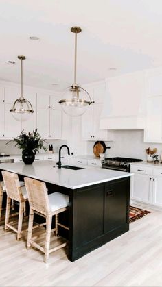 a kitchen with white cabinets and black island