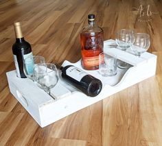 wine glasses and bottles are sitting on a tray