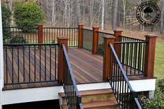 a wooden deck with metal railing and handrails