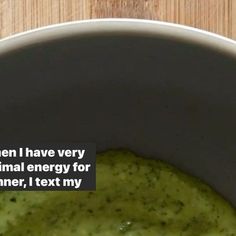 a bowl filled with green liquid on top of a wooden table